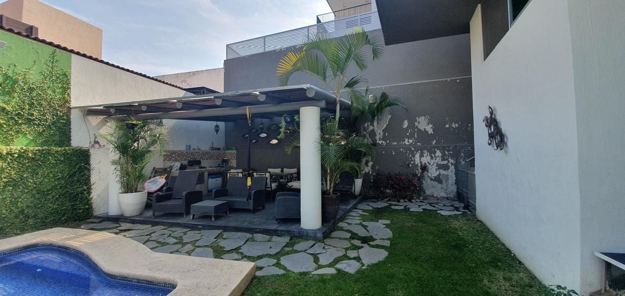Terraza y alberca originales, con pérgola de lona y muro descascarado