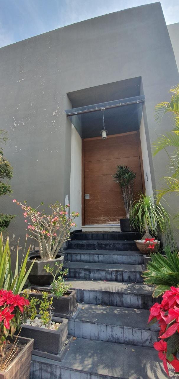 Acceso original: puerta de madera bajo marquesina y escalones de piedra oscura